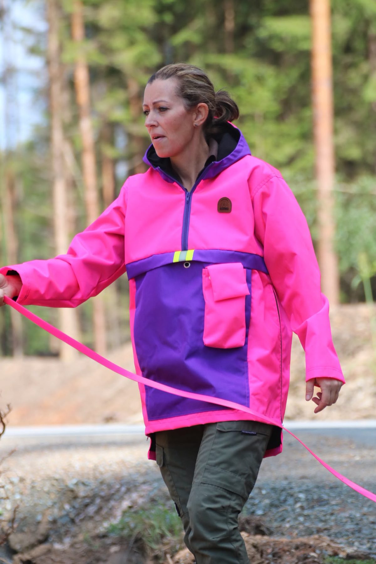 Hundeführerjacke in Pink und Lila mit Reflexstreifen, Frontansicht mit Tasche